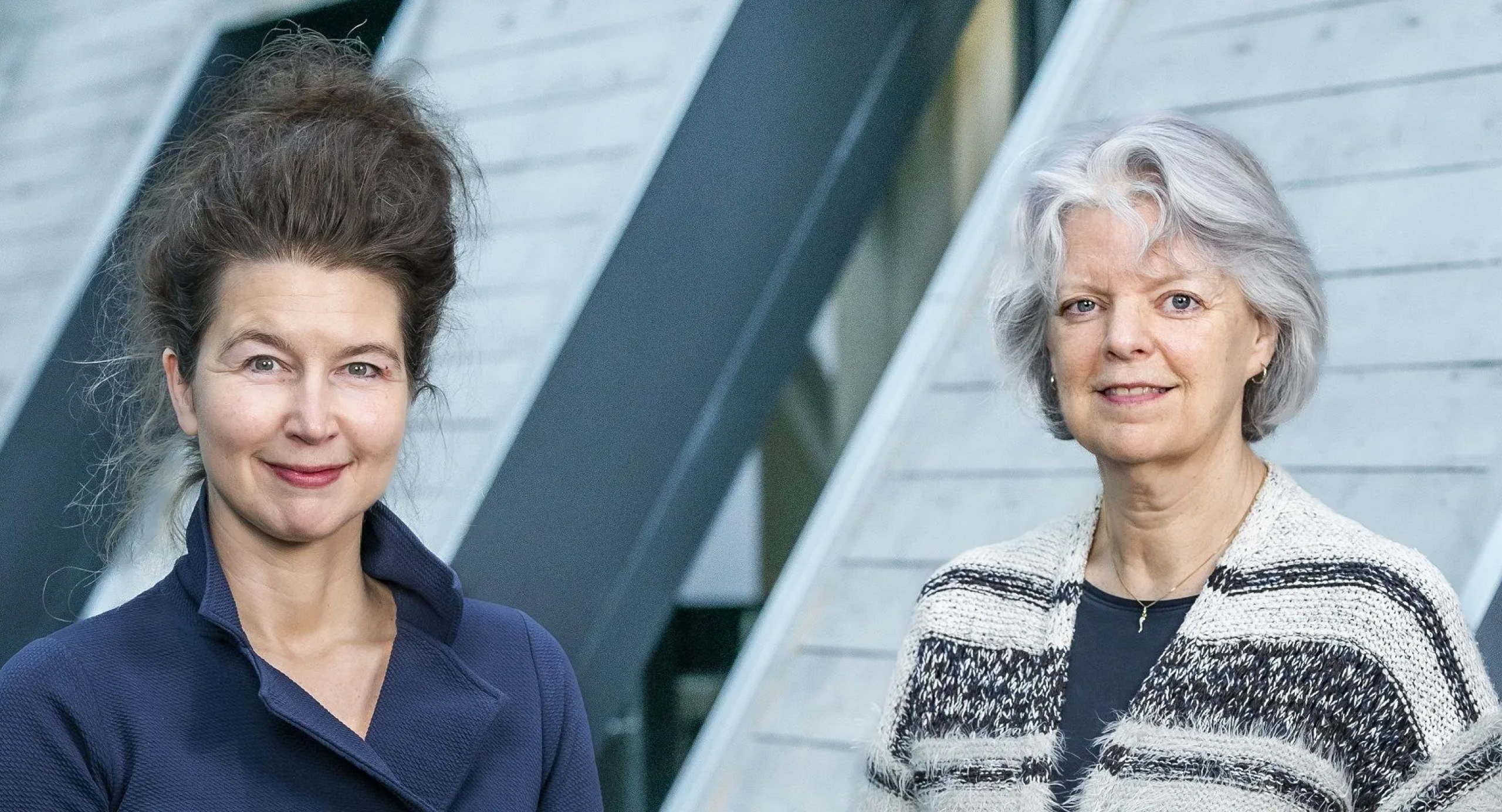 twee vrouwen die naast elkaar staan en naar de camera kijken.