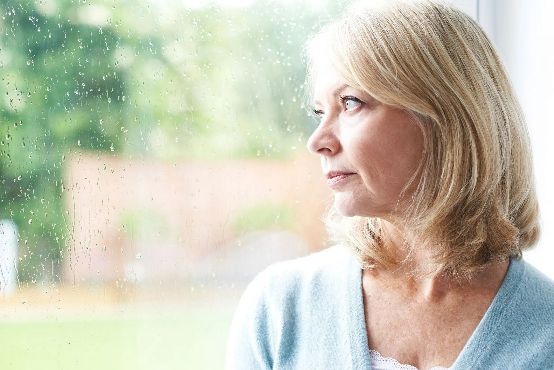 vrouw kijkt uit het raam